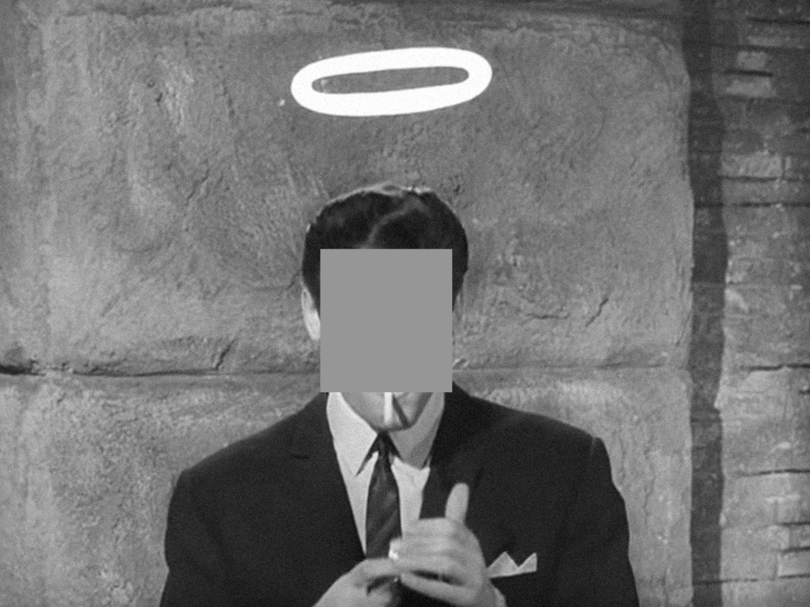Black-and-white still of a man in a suit and tie with a drawn halo above his head, face obscured